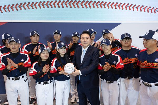 &nbsp;윤석열&nbsp;대통령이 14일 청와대 영빈관에서 열린 탈북민 청소년 야구단 '챌린저스'의 미국 방문 출정식에서 친필 사인한 대형 야구공을 들고 야구단원들과 기념 촬영을 하고 있다. [사진=대통령실 제공]