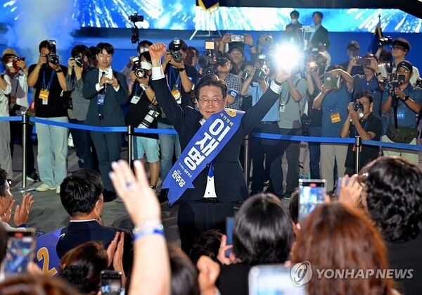 더불어민주당 당대표 연임이 확정된 이재명 당대표가 18일 오후 서울 송파구 올림픽공원 KSPO돔에서 열린 전국당원대회에서 개표결과가 발표되자 당원들을 향해 두 팔을 들어 인사하고 있다.2024.8.18 [공동취재] [사진=연합뉴스]