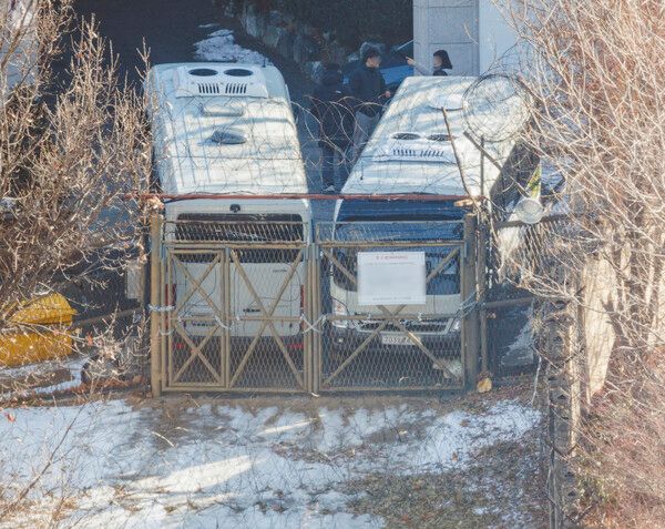 법원이 윤석열 대통령에 대한&nbsp;체포영장을 재발부해 공조수사본부 차원의 영장 2차 집행 시도가 초읽기에 들어간 9일 오전 서울 용산구 한남동 대통령 관저에서 경호처 직원이 철조망이 쳐진 쪽문을 버스로 벽을 치고 있다.이 쪽문은 전날 쇠사슬을 묶었고, 이날 버스로 차벽을 추가했다.[사진=연합뉴스]