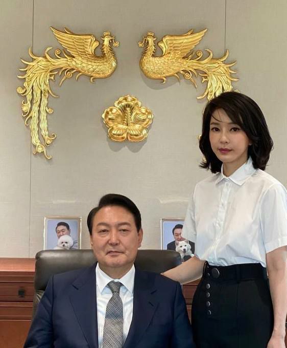윤석열 대통령과 김건희 여사가 대통령실 집무실에서 대통령 표장을 배경으로 촬영한 사진이 30일 공개됐다.윤 대통령 뒤로는 반려견 토리, 써니와 함께 찍은 윤 대통령의 사진이 놓여 있다. 2022.5.30 [대통령실 관계자 제공. 재판매 및 DB금지] [사진=연합뉴스]