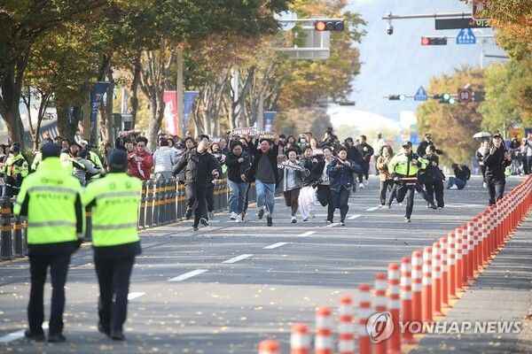 한미 정상회담이 열린 국립경주박물관 인근에서 도널드 트럼프 미국 대통령을 반대하는 기습 시위대가 경찰저지선을 뚫고 정상회담장으로 질주하고 있다 [사진=연합뉴스]