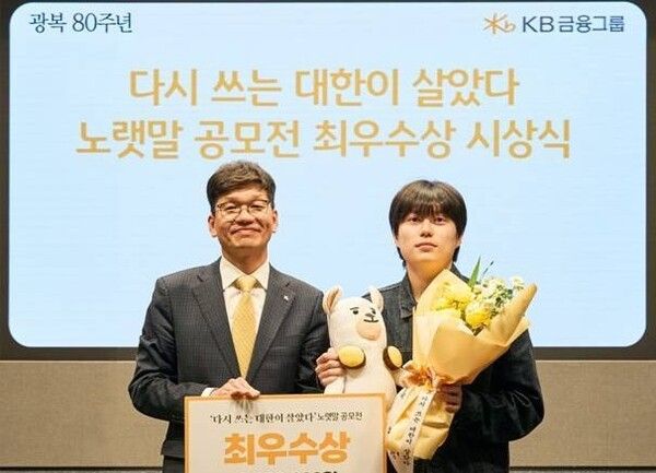 박진영&nbsp;KB금융지주 상무(브랜드담당&nbsp;CPROㆍ왼쪽)와 최우수상 수상자 한성일 씨가 '다시 쓰는 대한이 살았다'&nbsp;노랫말 공모전&nbsp;최우수상 시상식에서&nbsp;기념 촬영을 하고 있다.[사진=KB금융그룹]