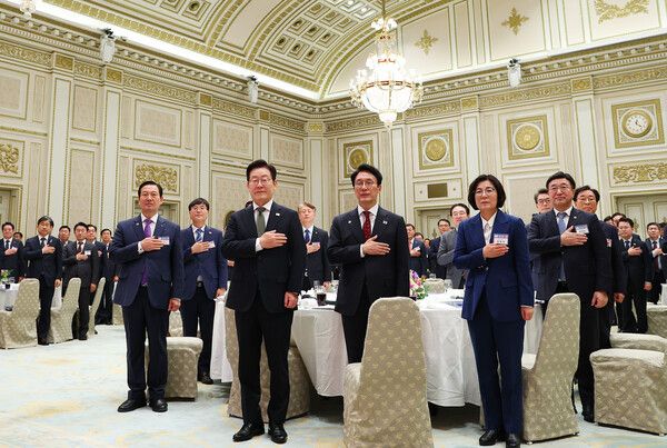 이재명 대통령이&nbsp;12일&nbsp;청와대&nbsp;영빈관에서 열린 시장·군수·구청장 초청 국정설명회에서 국기에 경례하고 있다. 정 구청장은 이날 이 대통령, 김민석 국무총리와 같은 테이블에 앉아 주목을 받았다. [사진=연합뉴스]