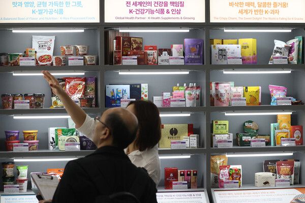 사진은 지난달 29일 서울 강남구 코엑스에서 열린 '2025 푸드위크 코리아'에서 한 참관객이 'K-푸드' 제품 설명을 듣는 모습 [사진=연합뉴스]