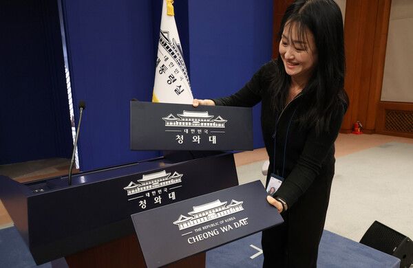 용산 대통령실 이전 작업을 본격화한 21일&nbsp;청와대&nbsp;브리핑룸에서 한 직원이 탈부착 업무표장을 설치하고 있다. [사진=연합뉴스]