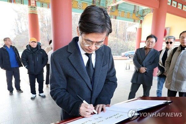 12·3 비상계엄 사태 1주년인 3일 오후 광주 북구 국립 5·18 민주묘지에서 국민의힘 조경태 의원(부산 사하구을)이 참배 전 방명록을 작성하고 있다 [사진=연합뉴스]