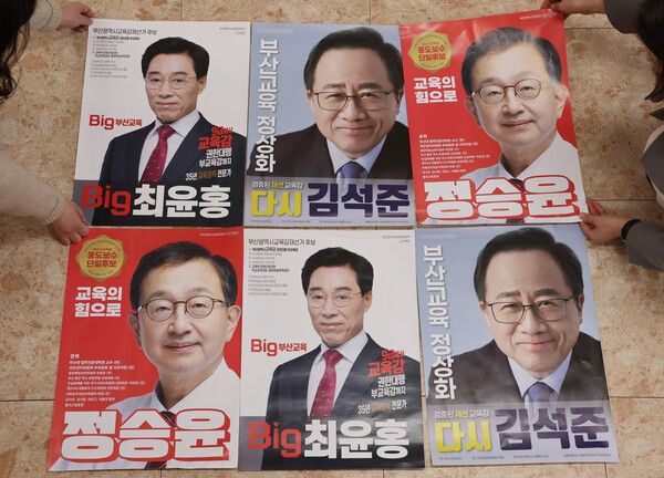 4·2&nbsp;재보궐선거 공식 선거운동 기간을 하루 앞둔 19일 오후 부산시선거관리위원회에서 선관위 직원들이 부산시 교육감 후보들의 선거 벽보를 살펴보고 있다. [사진=연합뉴스]