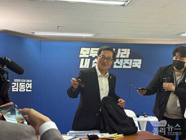 김동연 예비후보가 16일 ‘백팩 메고 TMI(도어스테핑)’ 기자 간담회에서 자신의 백팩에 들어있는 빗을 꺼내고 있다. [사진=안다인 기자]