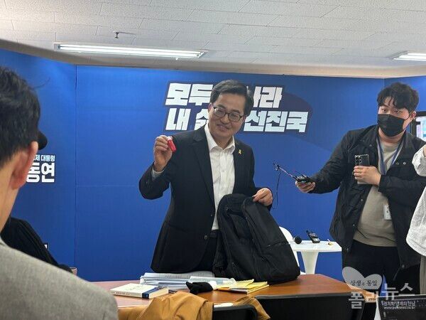 김동연 예비후보가 16일 ‘백팩 메고 TMI(도어스테핑)’ 기자 간담회에서 자신의 백팩에 들어있는 립밤을 꺼내고 있다. [사진=안다인 기자]