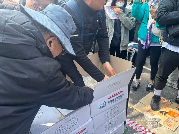 한 남성이 선고 결과가 나오자 직접 주문해 온 떡 8박스를&nbsp; 수레를 끌고 다니며 집회 참가자들에게 나눠 주기도 했다.[사진=안다인 기자]&nbsp;