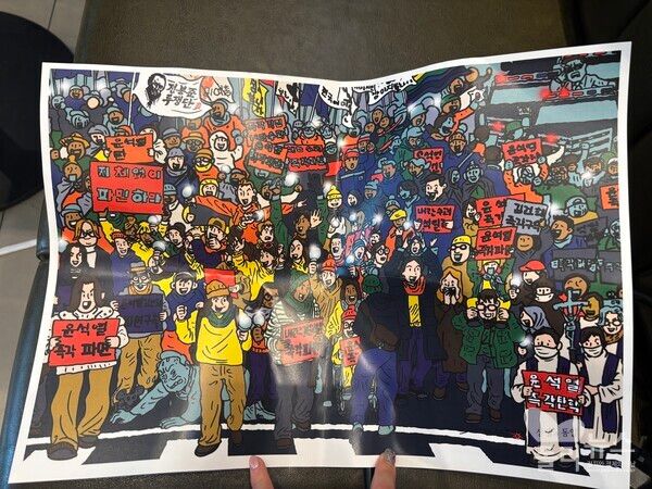 파면 선고가 난 뒤 지금까지 집회에 참여한 사람들을 그린 그림을 나눠 주기도 했다.&nbsp;[사진=안다인 기자]