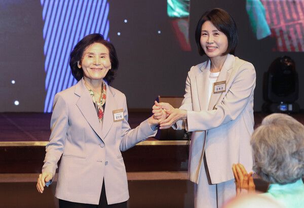 &nbsp;국민의힘 김문수 대선 후보의 부인 설난영 씨(왼쪽)와 더불어민주당 이재명 대선 후보의 부인 김혜경 씨가 12일 서울 중구 신라호텔에서 열린 중앙신도회 창립 70주년 기념식에서 손을 맞잡고 있다. [사진=연합뉴스]