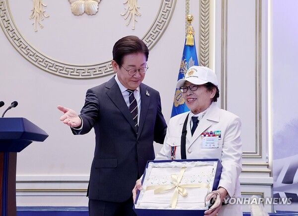 이춘자 씨에게 광목이불 선물하는 이재명 대통령 [사진=연합뉴스]