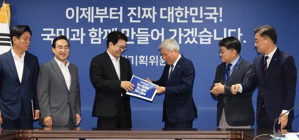 국정기획위원회 이한주 위원장이 2일 서울 종로구 국정기획위원회에서 조국혁신당 원내대표단 접견에 앞서&nbsp;서왕진&nbsp;원내대표로부터 정책과제를 전달받고 있다. [사진=연합뉴스]