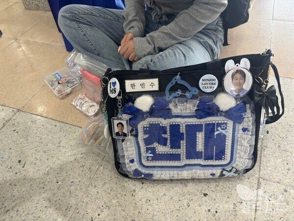 박찬대 후보와 한민수 의원을 응원하는 한 당원이 굿즈를 만들어서 나눠주고 있다.&nbsp;[사진=안다인 기자]