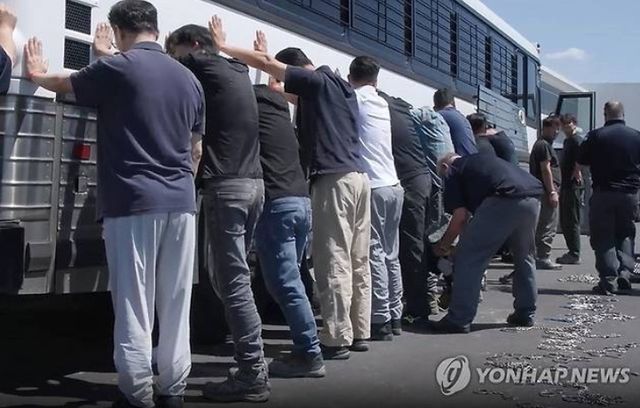 지난 4일(미 현지시간) 현대자동차-LG에너지솔루션 합작 배터리 공장에 군용차량, 총, 쇠사슬을 들고 급습한 미 이민세관단속국(ICE)에 의해 한국인 317명이 '중범죄자' 취급을 받으며 체포, 구금됐다. ICE요원은 우리 국민들을 버스에 양손을 짚고 일렬로 늘어선 현장 직원들을 단속 요원이 다리에 쇠사슬 체인을 묶고 있다. [사진=이민세관단속국(ICE) 누리집 갈무리=연합뉴스]