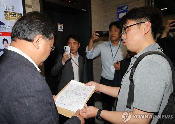 김건희 여사의 의혹들을 수사하는 민중기 특별검사팀이 18일 서울 여의도 국민의힘 중앙당사에 대한 '통일교 집단 입당' 의혹과 관련한 압수수색에 나섰다. 당사에 도착한 특검팀이 18일 국민의힘 측 변호사에게 영장을 제시하고 있다. [사진=연합뉴스]