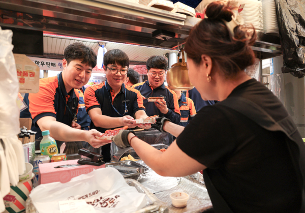 포항제철소 직원들이 대해불빛시장에서 음식을 사고 있다. / 사진=포스코