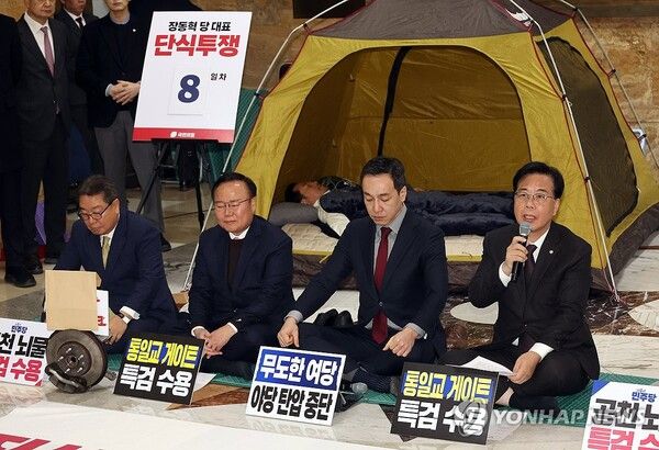 통일교·공천헌금 '쌍특검' 입법을 요구하며 단식 투쟁에 나선 지 8일 차를 맞은 국민의힘 장동혁 대표가 22일 국회 로텐더홀 텐트 안에 누워있는 동안 최고위원회의가 열리고 있다. [사진=연합뉴스]