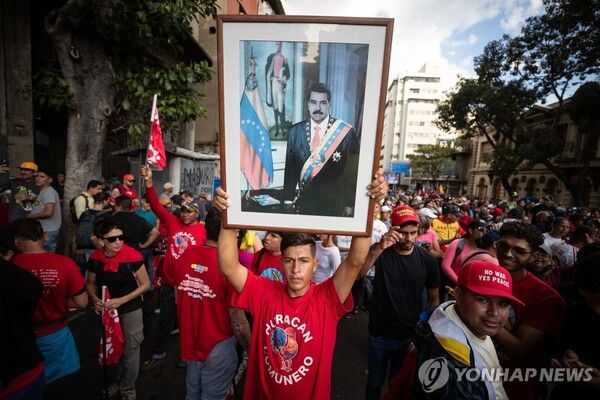 4일 베네수엘라 수도 카라카스에서 열린 니콜라스 마두로 대통령 석방 촉구 시위에서 한 남성이 마두로 대통령 사진을 들고 있다 [사진=EPA=연합뉴스]