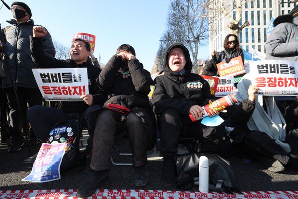 &nbsp;촛불행동 관계자들이 19일 서울 서초구 서울중앙지법 인근에서 12·3 비상계엄과 관련해 내란 우두머리 혐의로 기소된&nbsp;윤석열&nbsp;전 대통령에 대한 1심 선고가 사형이 아닌 무기징역 판결이 나자 눈물을 보이고 있다. [사진=연합뉴스]