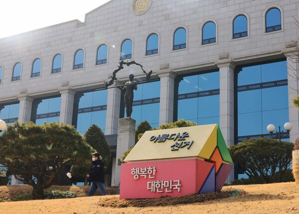 22일 과천 중앙선거관리위원회에서 시민이 선관위 간판 앞을 지나고 있다. [사진=연합뉴스]