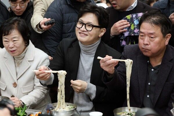 한동훈&nbsp;국민의힘 전 대표가 27일 오후&nbsp;대구&nbsp;서문시장을 찾은 자리에서 일행들과 국수를 먹고 있다. [사진=연합뉴스]