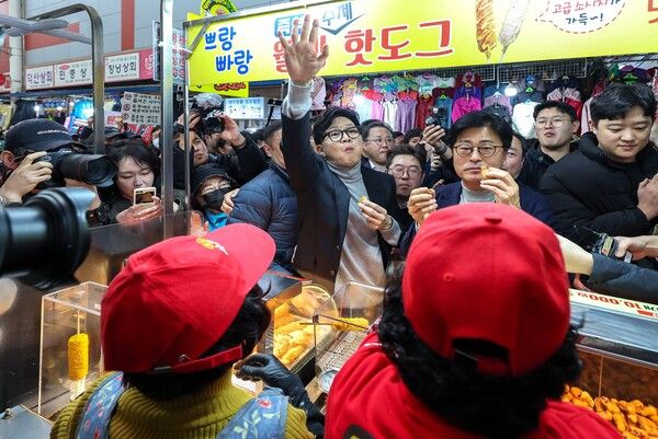 &nbsp;한동훈&nbsp;국민의힘 전 대표가 27일 오후 대구 서문시장에 도착해 상인들이 건네는 음식을 먹고 있다. [사진=연합뉴스]