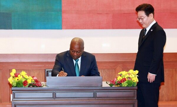 이재명&nbsp;대통령이 11일 청와대에서 존 드라마니 마하마 가나 대통령의 방명록 작성을 지켜보고 있다. [사진=연합뉴스]