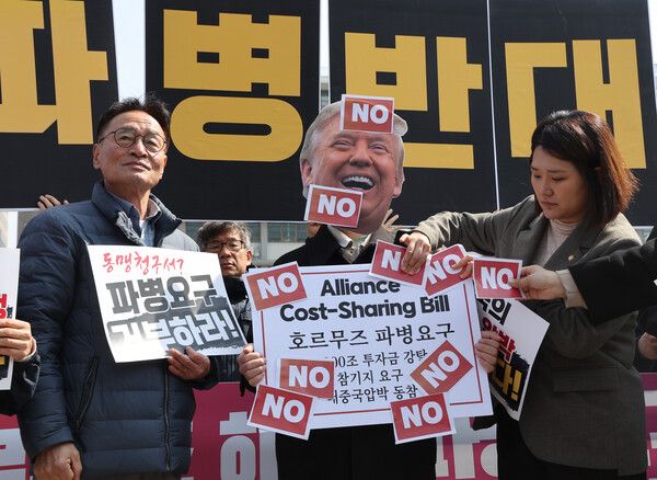 &nbsp;16일 서울 종로구 주한미국대사관 앞에서 열린 '미국의&nbsp;호르무즈&nbsp;해협 파병 요구 규탄 및 파병 반대 긴급 기자회견'에서 참가자들이 '호르무즈&nbsp;파병 요구' 라고 적힌 팻말에 'NO' 스티커를 붙이고 있다. [사진=연합뉴스]