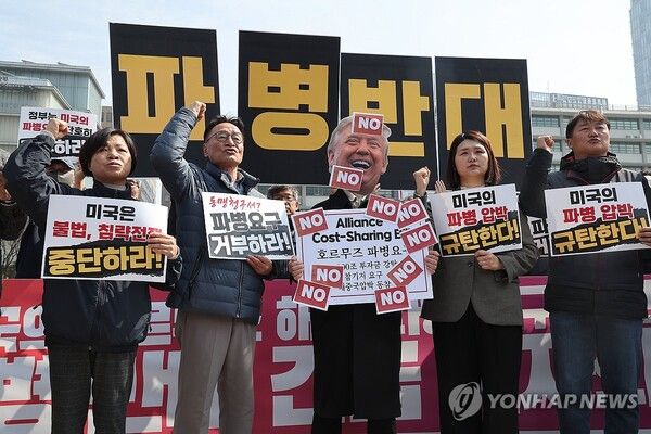 주한미국대사관 앞에서 열린 '미국의 호르무즈 해협 파병 요구 규탄 및 파병 반대 긴급 기자회견'에서 참가자들이 '호르무즈 파병 요구' 라고 적힌 팻말에 'NO' 스티커를 붙이고 구호를 외치고 있다 [사진=연합뉴스]