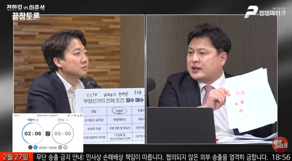 박주현 변호사가 27일 펜앤마이크 주최 부정선거 토론회에서 만년도장을 직접 들어 보이며 투표지 이중 날인 과정을 시연하고 있다. 박 변호사는 인천 연수을 제6투표소에서 1,974장 중 1,000장 이상이 인영이 겹친 투표지였다고 말했다. [출처=펜앤마이크 이준석-전한길 끝장토론 유튜브 라이브 갈무리]&nbsp;