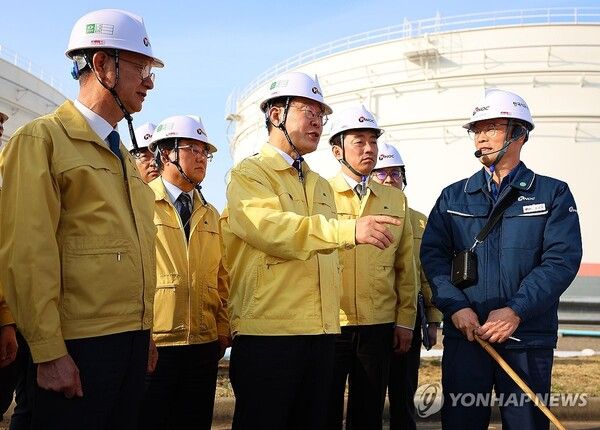 이재명 대통령이 26일 충남 한국석유공사 서산 비축기지에서 석유화학기업 간담회를 마친 뒤 원유탱크를 살펴보며 관계자에게 질문하고 있다 [사진=연합뉴스]