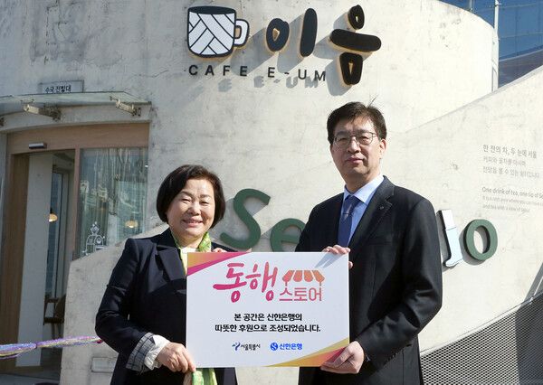 25일 서울로7017에서 진행한 '동행스토어' 3호점 '카페 이음' 개점식에서 강영홍 신한은행 경영지원그룹장(오른쪽)과 서정화 열린여성센터 원장이 기념촬영하는 모습. [사진=신한은행]