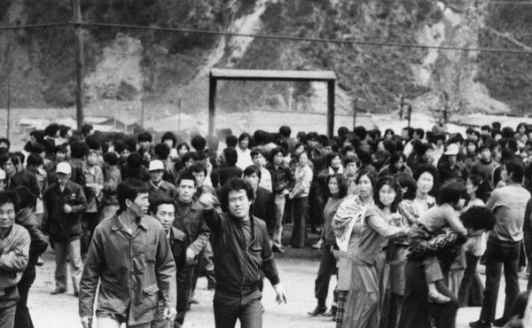 1980년 4월 23일 경 경찰병력을 몰아낸 광부와 부녀자들이 사북광업소 게시판 앞에서 사진을 찍는 기자들에게 항의하고 있다. [사진=서북항쟁동지회]