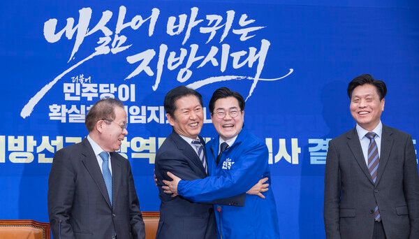 더불어민주당 정청래 대표(왼쪽 두 번째)가 4일 국회에서 열린 중앙당 공천관리위원회 지방선거 후보 공천 심사 결과 발표 회견에서 인천시장 후보로 결정된 박찬대 의원(왼쪽 세 번째)에게 당의 후보를 상징하는 파란 점퍼를 입혀준 뒤 포옹하고 있다. 2026.3.4. [사진=연합뉴스]