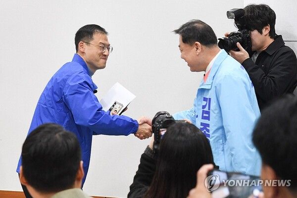 25일 울산시의회 프레스센터에서 더불어민주당 김상욱 의원(왼쪽)과 진보당 김종훈 전 동구청장이 우연히 만나 악수하고 있다.[사진=연합뉴스]