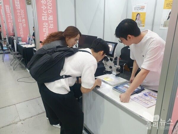 'KB굿잡 취업박람회' 한국폴리텍대학 부스에서 한 참석자가 반도체 웨이퍼를 현미경으로 관찰하고 있다.&nbsp; [사진=권은주 기자]