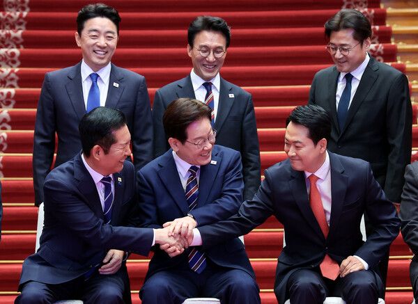 이재명&nbsp;대통령이 7일 청와대에서 여야정 민생경제 협의체 회담에 앞서 기념촬영 중 더불어민주당 정청래 대표, 국민의힘 장동혁 대표와 손을 잡고 있다. 뒷줄은 왼쪽부터 강훈식 대통령비서실장, 김민석 국무총리, 홍익표 정무수석. [사진=연합뉴스]