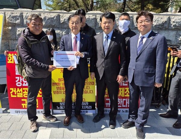 김윤덕 국토교통부 장관(왼쪽 두 번째)이 4월 7일 국회의사당 2문 앞 농성 현장에서 대우산업개발 노조위원장(맨 왼쪽)으로부터 '건설공제조합의 불법 채권회수 압박 중단 촉구' 문서를 전달받고 있다. 오른쪽부터 염태영 의원, 복기왕 의원. [사진=폴리뉴스]