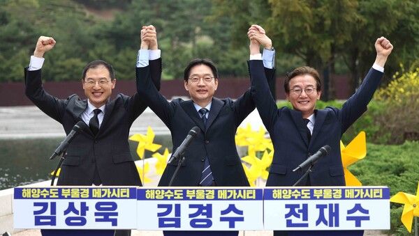 더불어민주당 부울경(부산·울산·경남) 시장·도지사 후보가 14일 오전 경남 김해시 진영읍 봉하마을에서 열린 '해양수도 부울경 메가시티 공동출정식'에서 취재진 요청에 손을 번쩍 들고 인사하고 있다.&nbsp;왼쪽부터 김상욱 울산시장 후보,&nbsp;김경수&nbsp;경남지사 후보, 전재수 부산시장 후보. [사진=연합뉴스]