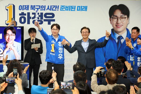 부산 북갑 국회의원 보궐선거에 출마하는 더불어민주당 하정우 후보가 10일 오후 부산 북구에서 열린 선거사무소 개소식에서&nbsp;전재수&nbsp;부산시장 후보가 건넨 '북구의 미래'가 적힌 바톤을 넘겨 받은 뒤 손을 잡고 있다. 북갑은&nbsp;전재수&nbsp;후보가 3선을 지낸 곳이다. [사진=연합뉴스]