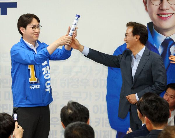 부산 북갑 국회의원 보궐선거에 출마하는 더불어민주당 하정우 후보가 10일 오후 부산 북구에서 열린 선거사무소 개소식에서&nbsp;전재수&nbsp;부산시장 후보가 건넨 '북구의 미래'가 적힌 바톤을 넘겨 받고 있다. 북갑은&nbsp;전재수&nbsp;후보가 3선을 지낸 곳이다. [사진=연합뉴스]