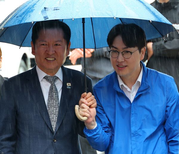 3일 오후 부산 북구 구포시장에서 더불어민주당 정청래 대표와 북갑 국회의원 보궐선거 출마를 공식화한 하정우&nbsp;전 청와대 AI 미래기획수석이 우산을 쓰고 이동하고 있다. [사진=연합뉴스]