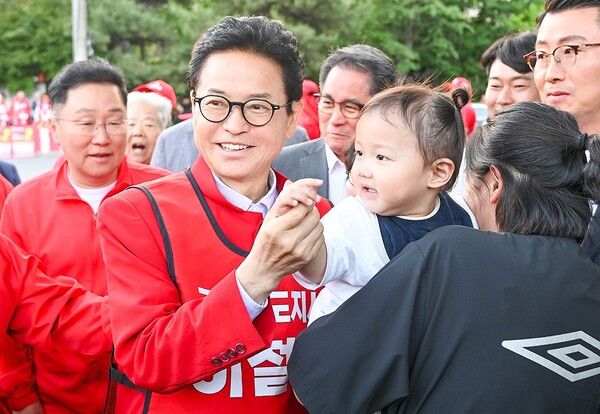 이철우 경북도지사 후보가 문경 유세 도중 엄마 품에 안긴 아기의 손을 잡고 있다. / 사진=이철우 경북도지사 후보 캠프