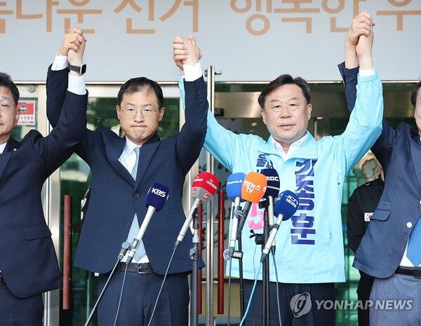 28일 울산시 중구 울산시선거관리위원회 앞에서 더불어민주당 김상욱(왼쪽), 진보당 김종훈 울산시장 후보가 김상욱 후보로의 단일화를 선언하고 함께 손을 잡고 인사하고 있다.[사진=연합뉴스]