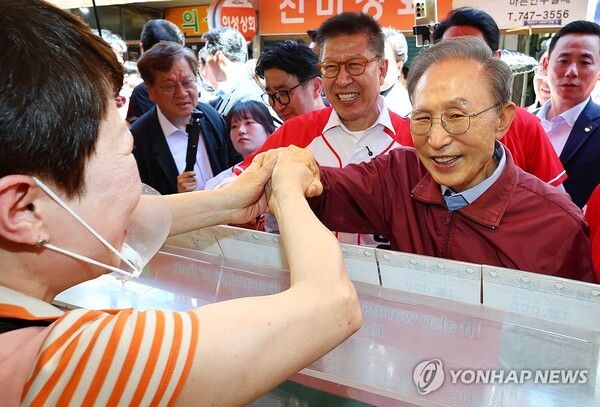 이명박 전 대통령이 31일 부산 해운대구의 한 족발 식당을 방문, 국민의힘 박형준 부산시장 후보의 지지를 호소하며 상인과 인사하고 있다.[사진=연합뉴스]