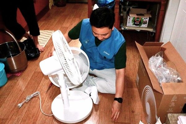 포스코 포항제철소 직원이 지역 어르신 가정을 방문해 선풍기를 조립하고 있다. / 사진=포스코