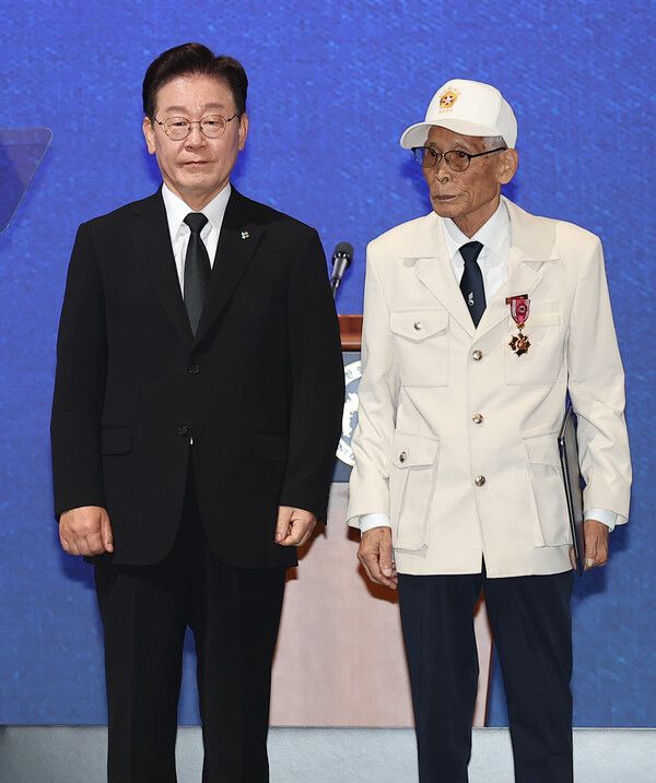 이재명&nbsp;대통령이 25일 수원컨벤션센터에서 열린 6·25전쟁 제76주년 기념식에서 비정규군 공로자 이영복 씨에게 화랑무공훈장을 수여한 후 기념촬영을 하고 있다. [사진=연합뉴스]