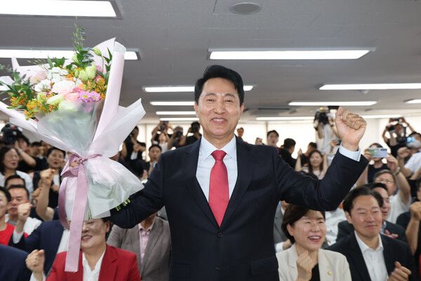 국민의힘&nbsp;오세훈&nbsp;서울시장 후보가 제9회 전국동시지방선거일 다음날인 4일 서울 종로구 대왕빌딩에 마련된 선거사무소에서 입장을 밝힌 뒤 꽃다발을 들어보이고 있다. [사진=연합뉴스]